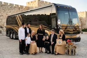 משפחה חוגגת לצד אוטובוס VIP מפואר עם רקע עדין של חומות העיר העתיקה, באווירה חגיגית.